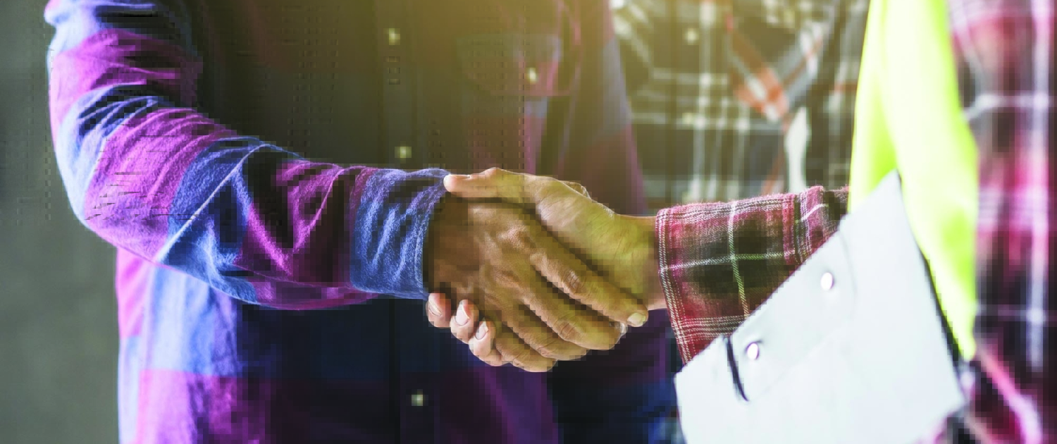 Two workers in plaid shaking hands